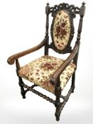 A carved oak armchair in floral upholstery, width 61 cm.