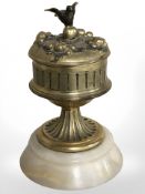 An onyx and gilt metal mounted ink well with ceramic liner surmounted by a bird, height 11 cm.