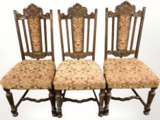 A set of three carved oak chairs in studded upholstery.