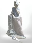 A Lladro figure of a lady with a parasol leaning against a pillar, height 38.5 cm.