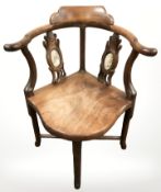 A Chinese carved hardwood corner armchair.