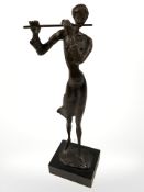 A cast and patinated metal modernist figure of a lady playing a flute, height 37 cm.
