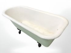An enameled metal roll top bath on cast iron claw and ball feet, 172 cm x 78 cm x 64 cm.