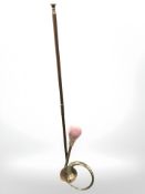 A copper horn and a further brass example, longest 110 cm.