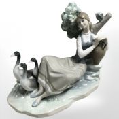 A Lladro figure of a lady reclining against a tree stump with three geese, height 21 cm.