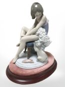 A Lladro figure of a seated ballerina with cat on oval plinth,