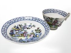 A 19th century blue and white transfer printed tea cup and saucer with overpainted decoration
