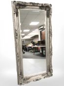 An ornate silvered floor standing mirror 177 cm x 90 cm