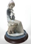 A Lladro figure of a lady cradling a lamb, number 1278 on circular plinth,