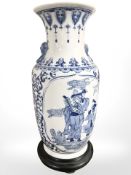 A large reproduction Chinese blue and white porcelain vase on ebonised stand, overall 53 cm high.
