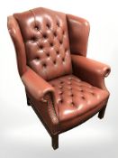 A red buttoned leather Chesterfield wingback armchair.