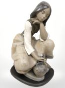 A Lladro matt glaze figure of a girl kneeling, on wooden plinth,