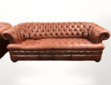 A red buttoned leather Chesterfield three seater settee, 226 cm long.