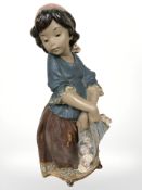 A Lladro bisque figure of a girl holding a bundle of roses,