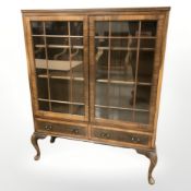 A glazed walnut double door display cabinet,