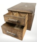 A 1920s oak counter top two drawer chest, width 24 cm.