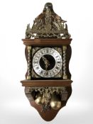 A reproduction Dutch wall clock with brass pear drop weights, length 50 cm.