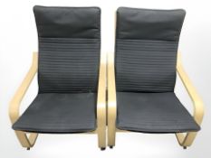 A pair of Ikea Poang bent and laminated wood armchairs with black fabric seats,