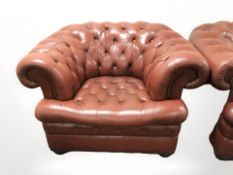 A red buttoned leather Chesterfield armchair.