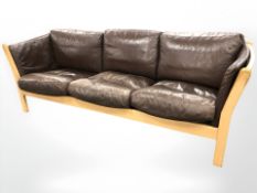 A late 20th century Danish wooden framed brown leather three seater settee, length 217 cm.