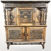 A 1930's heavily carved oak court cupboard,