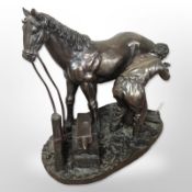 A resin figure of a farrier, together with a further figure of a jockey on horseback, tallest 26cm.