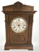 An early 20th century oak mantle clock, striking on a gong, height 36 cm.