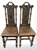 A pair of 19th century heavily carved oak hall chairs.