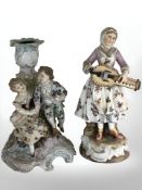 A German Volkstedt figural porcelain candlestick and a further depicting a lady playing a