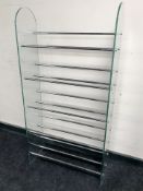 A glass and chrome shoe rack, width 61 cm.