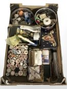Assorted spools of thread, knitting needles and similar haberdashery items.