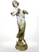 A Royal Vienna porcelain figure of a lady in flowing dress holding a cornucopia containing bushels