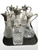 Five EPNS mounted claret jugs and a further decanter.