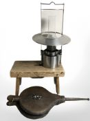 A set of fire bellows, a pine cracket and a hanging oil lamp.