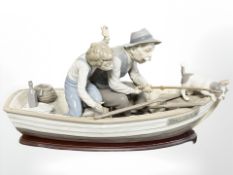 A Lladro figure group of a boy and grandfather fishing in a rowing boat, No.