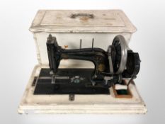 A Victorian cast-iron hand sewing machine in painted box.