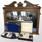 A carved walnut over mantle mirror and two cases of cutlery.
