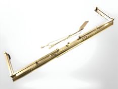 A Victorian telescopic brass fire curb and a three piece companion set.