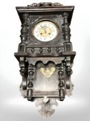 An early 20th century continental carved oak wall clock, with pendulum, length 73 cm.