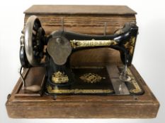 A Singer hand sewing machine in oak case and a further sewing machine