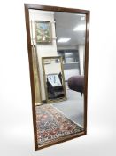 A mahogany bevelled mirror, 63 cm x 136 cm.