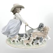 A Lladro figure group of a girl walking dogs, No. 6784.