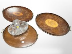 Three mahogany twin handled serving trays and a crystal basket.