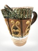 A decorative glazed earthen ware jug with folded handle,