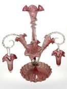 A Victorian cranberry glass epergne with four tapering glass flower holders and three twisted clear