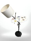 A lamp on cast metal support in the form of an artist's easel, height 104 cm.