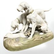 A Royal Dux figure group of two hounds standing over a dead hare,