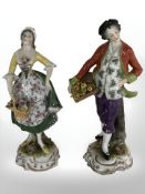 A pair of Capodimonte figures of a lady and gentleman holding baskets of flowers and produce,