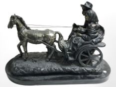 A patinated metal resin figure of two travellers on a horse drawn cart, length 44 cm.