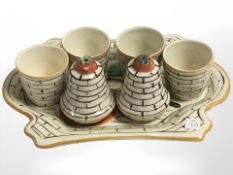 An Art Deco ceramic dish with four matching egg cups and a pair of sifters, width 21 cm.